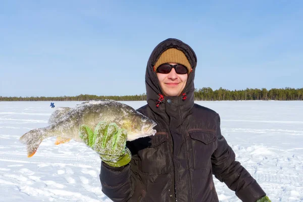 Young man holding fish catch a big pike ice fishing — Stock Photo, Image