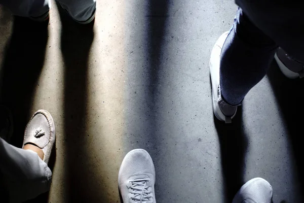 Schatten der Füße der Menschen schauen nach unten — Stockfoto