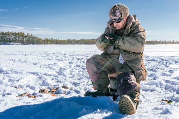 冬の釣り氷上で一日を楽しむ漁師 — ストック写真