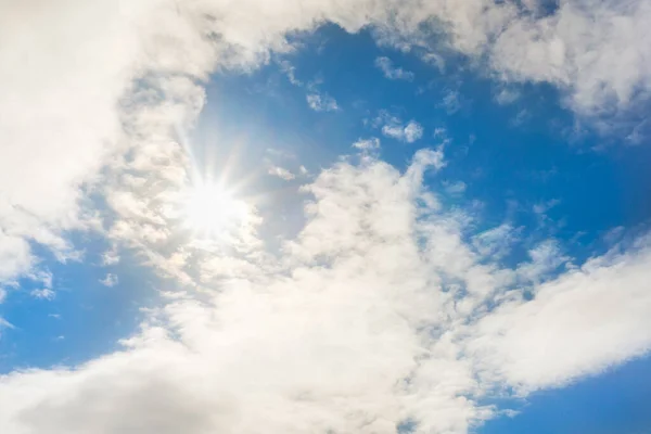 Bright sun in blue sky with clouds — Stock Photo, Image
