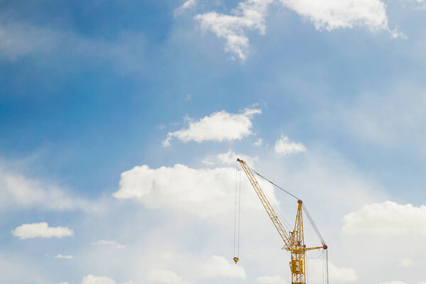 Construction crane at blue sky bright sunshine of the spring day