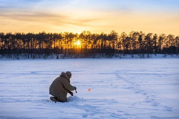 Pescador pesca de inverno ao amanhecer — Fotografia de Stock