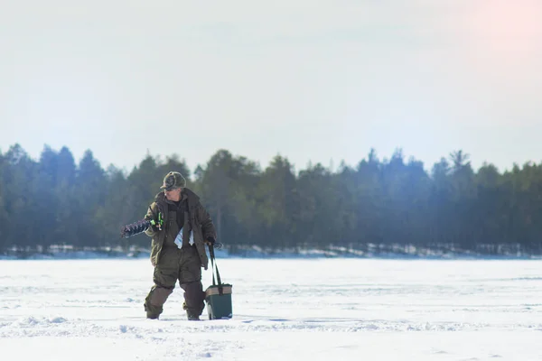 A man on a winter fishing drill hole ice drill — Stock Photo, Image