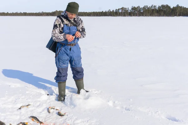 Fisherman fishing winter fishing on a bright Sunny day — Stock Photo, Image