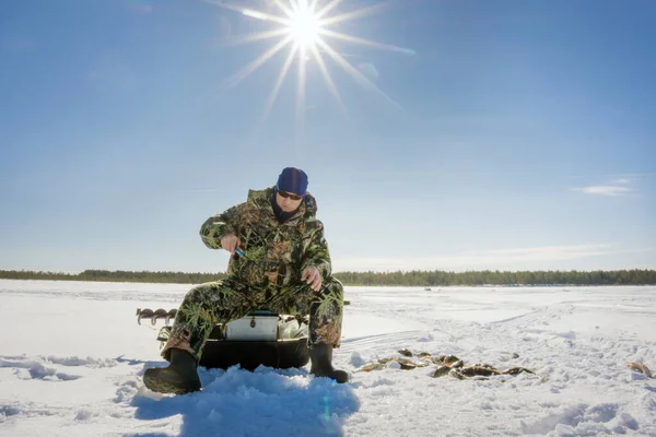 Fisherman fishing winter fishing on a bright Sunny day — Stock Photo, Image