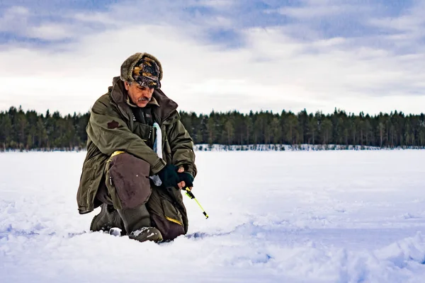 Man catches a fish in the winter — Stock Photo, Image