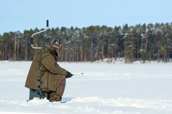 Man fishing in winter on an icy lake. Winter sport winter fishing — Stock Photo, Image