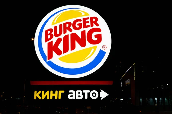 Tyumen, Rússia - 03 de outubro de 2019: Burger King restaurante exterior-sinal perto da entrada principal à noite. Venda de fast food fast food — Fotografia de Stock