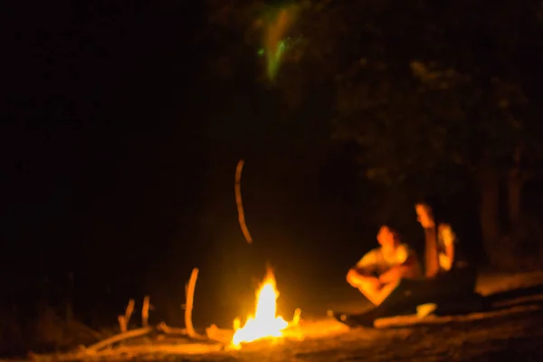 Couple in love on blurred background at campfire in forest Royalty Free Stock Images