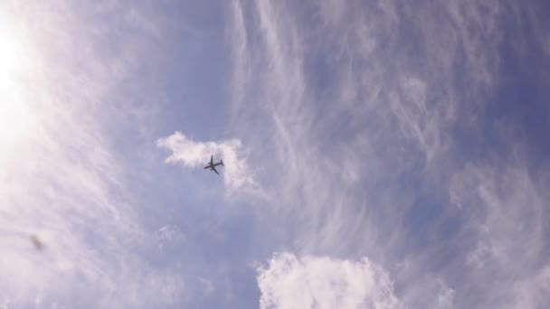 雲に覆われた青い空を背景に飛行機は — ストック動画