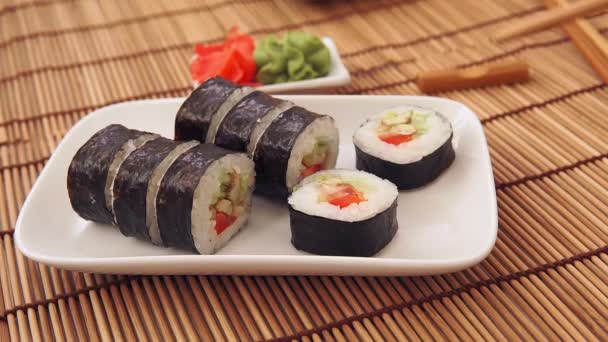 Chopsticks tomando uma porção de sushi rolar na mesa do restaurante comer sushi — Vídeo de Stock