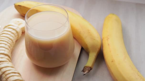 Банановый сок на белом фоне. Свежие фрукты, избирательная концентрация. для копирования пространства — стоковое видео
