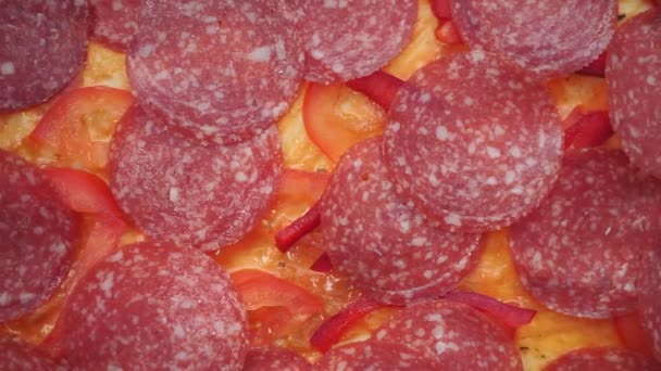 Cuisson de pizza maison avec des tomates pepperoni saucisse, fromage, salami close-up — Video