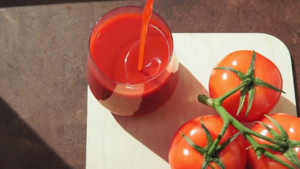 Thick tomato juice pours from a bottle into a glass — Stock Video