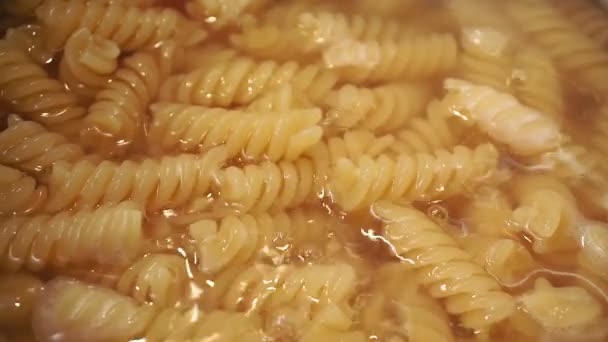 Boiling fusilli macaroni in a pot close up. Steam and Bubbling of hot water. — Stock Video