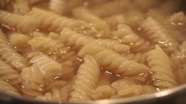 Fusilli macaroni close up in boiling water — Stock Video