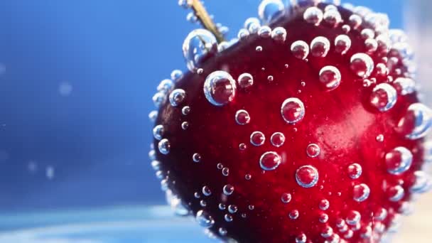 As cerejas salpicam na água. Close-up, macro. Use para publicidade de bebidas frescas. Coquetéis publicitários. Frutos suculentos . — Vídeo de Stock