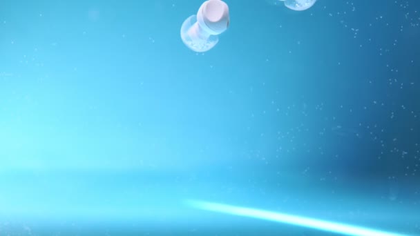 Наушники в воде под водой, выборочная фокусировка, музыкальная концепция — стоковое видео