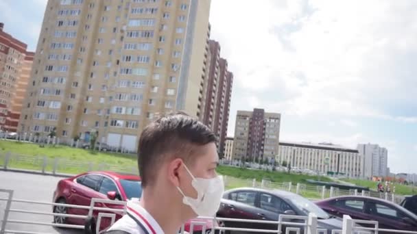 Ein Mann mit medizinischer Maske geht während der Quarantäne durch die Straßen der Stadt. Quarantäne, Coronavirus — Stockvideo