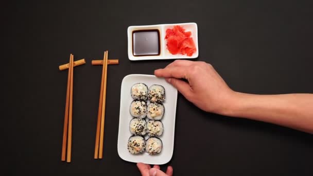 Sushi sashimi, maki rolt. Op plaat over zwarte achtergrond met ruimte voor je tekst. Bovenaanzicht vlak lay — Stockvideo