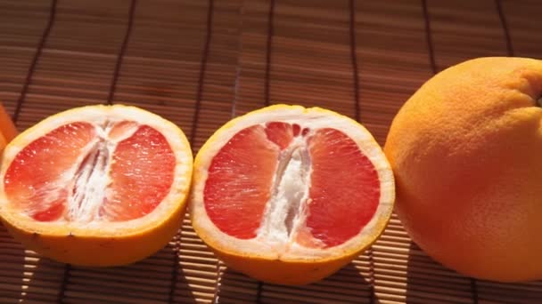 Склянка стиглого грейпфрута з соком на столі крупним планом — стокове відео