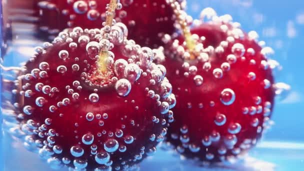 Kersen spatten op water. Een close-up, macro. Gebruik voor reclame voor verse dranken. Reclame voor cocktails. Sappige vruchten. Gezonde vorm van productpromotie. — Stockvideo