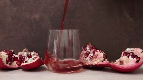 Häll juicen i ett glas med bitar av granatäpple. selektivt fokus — Stockvideo