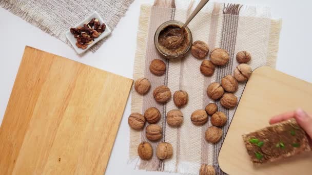 Surowe organiczne masło orzechowe lub pasta, świeże orzechy na stole kuchennym. Widok z góry — Wideo stockowe