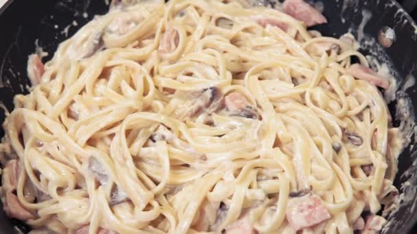 Carbonara w sosie śmietankowym z szynką i grzybami. Tradycyjna kuchnia włoska i przygotowanie żywności. Makaron Alla — Wideo stockowe