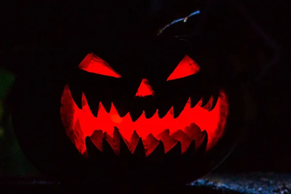 Scary smiling Halloween pumpkin on dark background. retro style, noise, selective focus