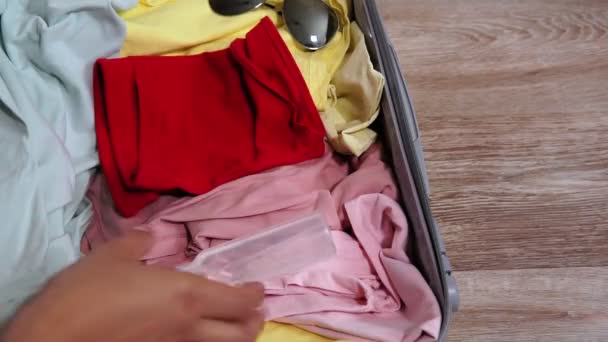 Koffer met beschermend wit masker, kleding, handreiniger gel. Nieuw reizend leven Coronavirus quarantaine. — Stockvideo