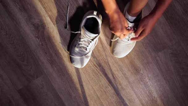 L'uomo si lega le scarpe. L'atleta si lega i lacci delle scarpe prima dell'allenamento. Chiudere. focus selettivo — Video Stock