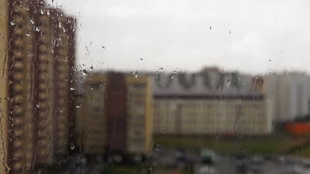 Gotas de lluvia cayendo sobre la ventana de cristal. Clima lluvioso, enfoque selectivo — Vídeo de stock
