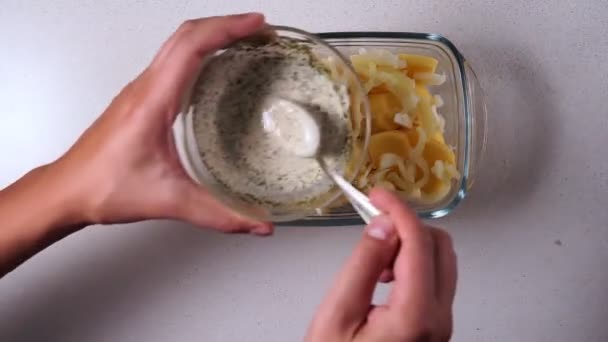 Mano está vertiendo salsa sobre las patatas crudas. vista desde arriba. enfoque selectivo — Vídeos de Stock