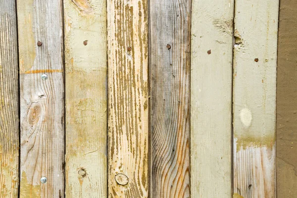 old retro texture of wooden yellow fence old paint with nails. background