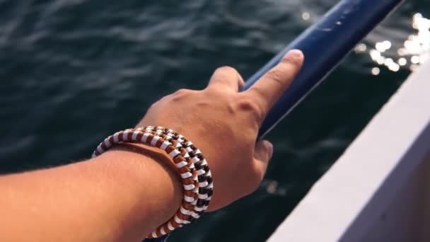 Χέρι ενός ανθρώπου στη θάλασσα επιλεκτική εστίαση. ταξιδεύουν με κρουαζιερόπλοιο. Κλείσιμο των χεριών με φόντο τη θάλασσα των ωκεανών. — Αρχείο Βίντεο