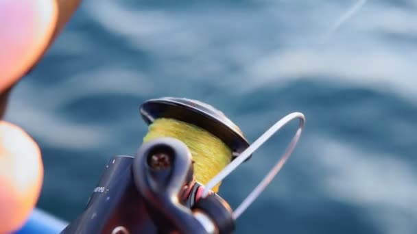 Närbild av en trollingrulle mot havet. Fiske och fiske tillbehör.havsfiske på sommaren — Stockvideo
