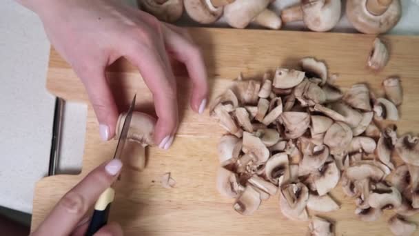 Mãos de mulheres cortar cogumelos na cozinha. preparação de alimentos — Vídeo de Stock