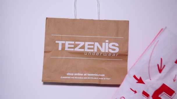 Tyumen, Rússia-01 de agosto de 2020: sacos de compras, vista superior. Logotipo Tezenis. Tezenis é uma marca de moda italiana própria da Calzedonia — Vídeo de Stock