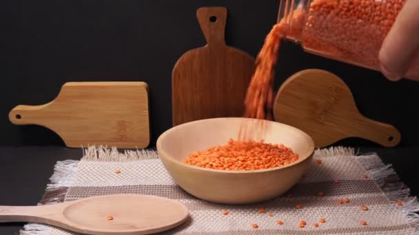 Vierte lentejas naranjas en un tazón de madera. Estilo de vida saludable. Dieta vegetariana y vegana. — Vídeos de Stock