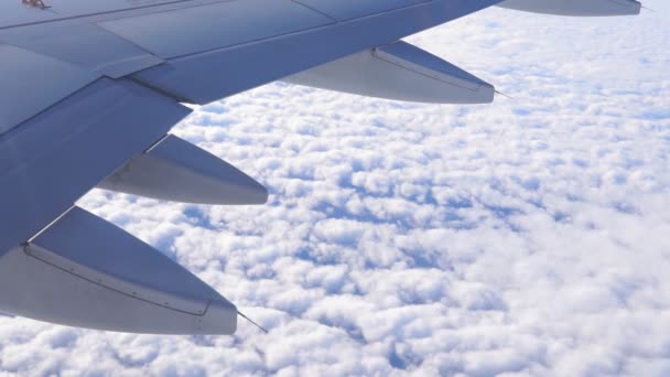 Avión volando sobre las nubes. Vista desde el ala del avión. Concepto de viaje — Vídeos de Stock