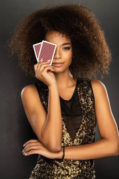 Young afro woman holding playing cards