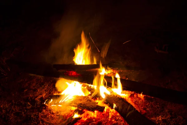 In der Nacht brennt ein kleines Feuer aus den Brettern und hat einen starken Schein — Stockfoto