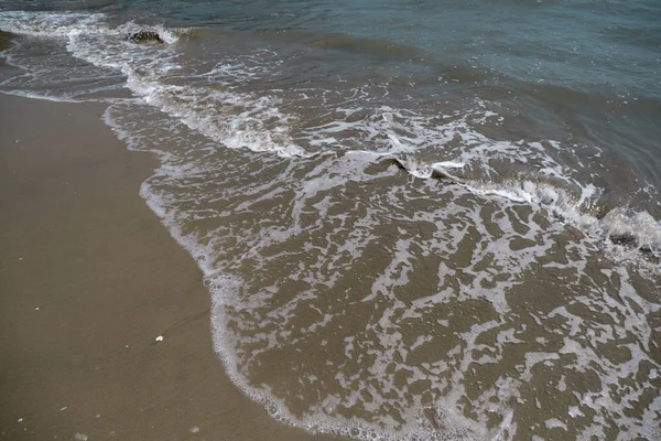 Piaszczysta plaża i małe fale. Dzień. — Zdjęcie stockowe