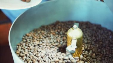 Kavrulmuş kahve karıştırma. Kötü tahıl kısmi kaldırılması. Kavrulmuş kahve çekirdekleri profesyonel bir makine tarafından sıralama karıştırıcı var. Ağır çekim.