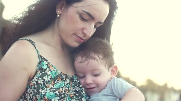 若い家族、彼女の腕の中で息子を持つ母です。幸せな息子に触れる手母の笑顔. — ストック動画