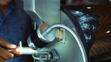 Profesyonel kahve çekirdekleri hazırlık denetler. Kahve çekirdekleri içinde kahvenin gerçek bir kahve yapmak için profesyonel bir makine kavrulmuş. Ağır çekim.