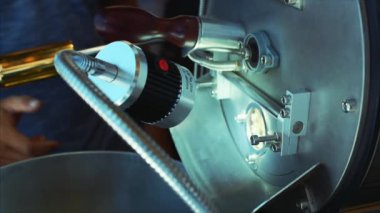 Profesyonel coffeemachine ve çiğ kahve çekirdekleri. Beyaz kahve çekirdekleri içinde kahvenin gerçek kahve yapmak için profesyonel bir makine yanmış. Ağır çekim.