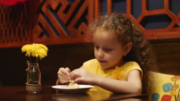 Kid sedí v kavárně a jíst tvarohový koláč. Detailní záběr. — Stock video