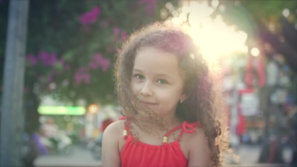 Kleines hübsches Mädchenporträt in der Nähe eines blühenden Baumes im Park. Konzept von Baby und natürlicher Schönheit. — Stockvideo